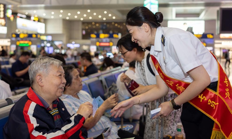 Staff members present gifts to passengers taking the high-speed sleeper train D907 bound for Hong Kong's West Kowloon Station at Shanghai Hongqiao Railway Station in east China's Shanghai, June 15, 2024. (Photo: Xinhua)