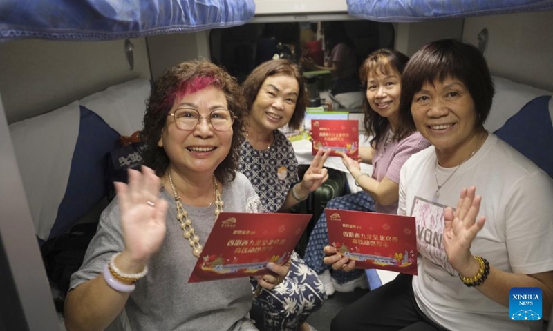 Passengers display gifts they received onboard the high-speed sleeper train D910 bound for Beijing West Railway Station, in Hong Kong, south China, June 15, 2024. (Photo: Xinhua)