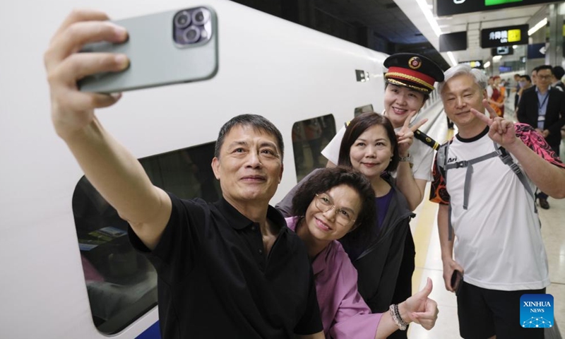 Passengers taking the high-speed sleeper train D910 bound for Beijing West Railway Station pose for a selfie at Hong Kong's West Kowloon Station in Hong Kong, south China, June 15, 2024. (Photo: Xinhua)