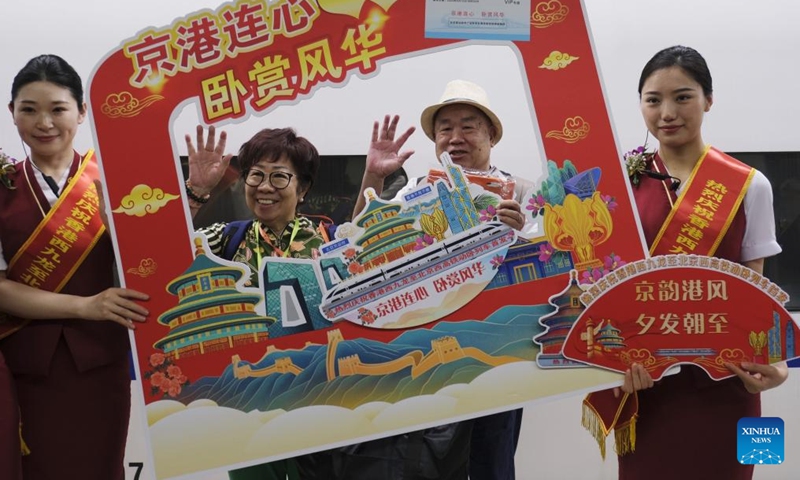 Passengers taking the high-speed sleeper train D910 bound for Beijing West Railway Station pose for photos at Hong Kong's West Kowloon Station in Hong Kong, south China, June 15, 2024. (Photo: Xinhua)