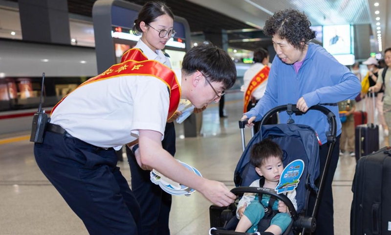 Staff members present gifts to passengers taking the high-speed sleeper train D907 bound for Hong Kong's West Kowloon Station at Shanghai Hongqiao Railway Station in east China's Shanghai, June 15, 2024. (Photo: Xinhua)