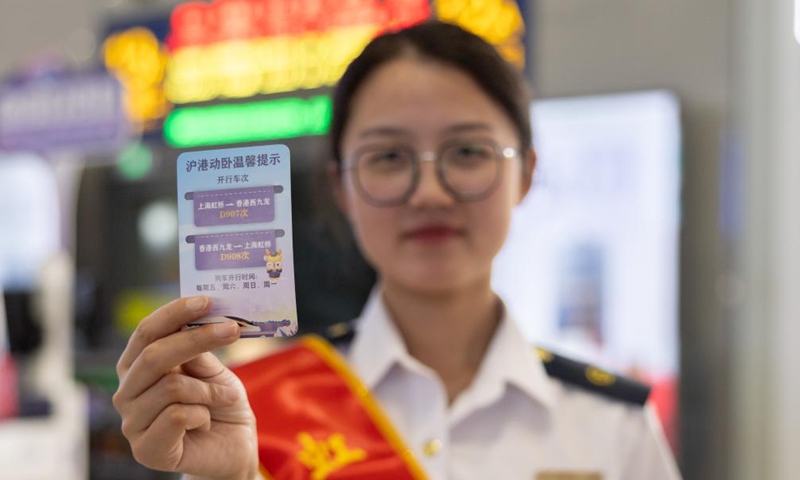 A staff member displays a reminder card of the high-speed sleeper trains D907 and D908 between Shanghai and Hong Kong, at Shanghai Hongqiao Railway Station in east China's Shanghai, June 15, 2024. High-speed sleeper trains linking Beijing and Shanghai with Hong Kong commenced operations on Saturday. (Photo: Xinhua)