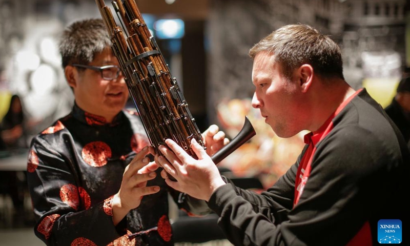 A man (R) tries traditional Chinese musical instrument sheng during the Getting to Know Chinese Folk Musical Instruments event at the Chinatown Storytelling Centre in Vancouver, British Columbia, Canada, on June 15, 2024. (Photo: Xinhua)