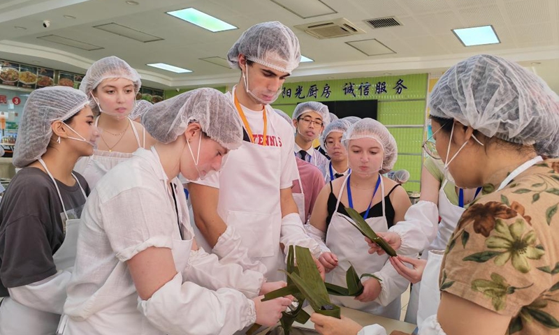 Brody Tate Clarke (4th L) from Iowa City High School learns to make zongzi at Shijiazhuang Foreign Language School in Shijiazhuang, north China's Hebei Province, June 8, 2024. (Photo: Xinhua)