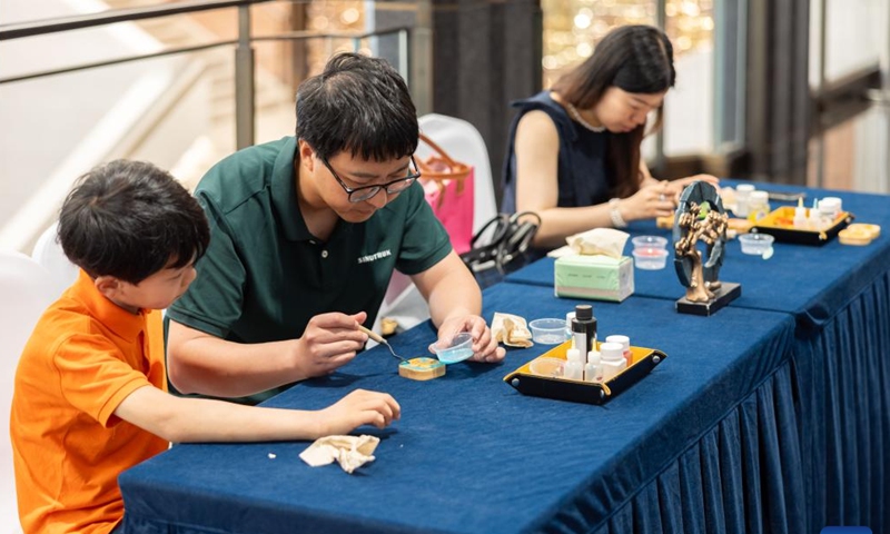 People experience the skills of cloisonne enameling at the Grand Halls in Shanghai, east China, June 16, 2024. The first public open day of the Grand Halls was launched in Shanghai on Sunday, attracting many visitors. Consisting of three old buildings with an area of 99,000 square meters, the Grand Halls previously was the Yangtze River wharf with a history of more than 100 years. (Photo: Xinhua)