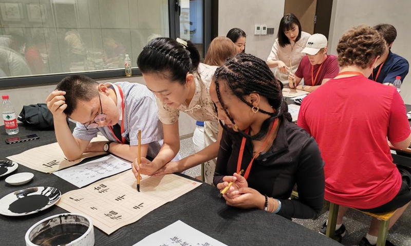 Chinese calligraphy teacher Fan Le (2nd L) demonstrates for Nasra Hassan Farah (3rd L) from Valley High School during her calligraphy practice at Shijiazhuang Foreign Language School in Shijiazhuang, north China's Hebei Province, June 8, 2024. (Photo: Xinhua)