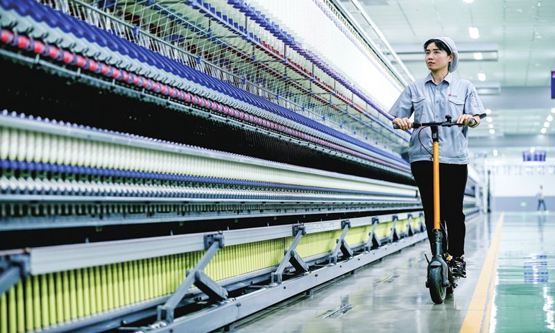 A worker inspects a smart production line of a spinning enterprise by riding a scooter in Qingdao, East China's Shandong Province on June 18, 2024. The local authorities offered to create more jobs in the textile, garment and other industries for residents to stabilize local employment while raising their incomes. 
Photo: VCG