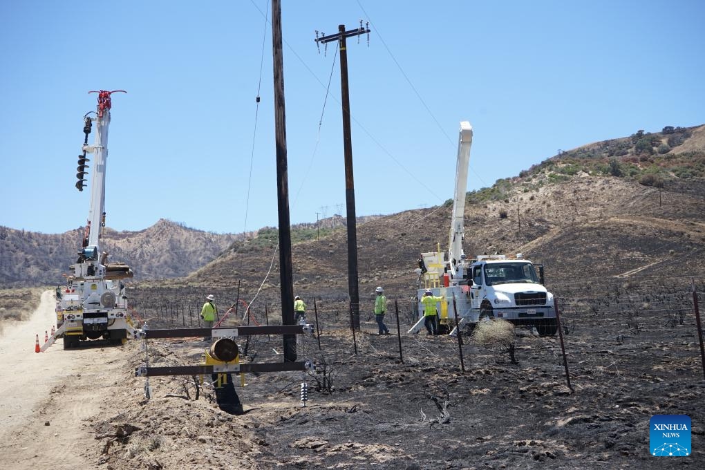 Emergency crew members work to restore electricity lines at the site where wildfires broke out in Gorman, about 100 km north of Los Angeles, California, the United States, on June 17, 2024. Firefighters are continuing to battle a string of wildfires across the western U.S. state of California on Monday amid high temperatures, lower humidity and strong winds.(Photo: Xinhua)