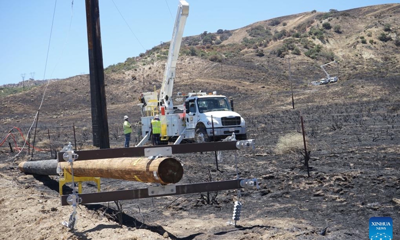 Emergency crew members work to restore electricity lines at the site where wildfires broke out in Gorman, about 100 km north of Los Angeles, California, the United States, on June 17, 2024. Firefighters are continuing to battle a string of wildfires across the western U.S. state of California on Monday amid high temperatures, lower humidity and strong winds.(Photo: Xinhua)