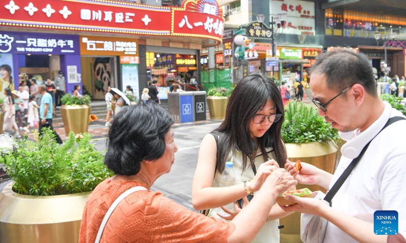 Tourists from Indonesia enjoy snacks at Jiefangbei, a core business area in southwest China's Chongqing, July 17, 2024.

Chongqing is soaring as a favored entry point for foreign tourists. This municipality has received more than 510,000 inbound foreign visitors in the first half of this year. (Xinhua/Wang Quanchao)