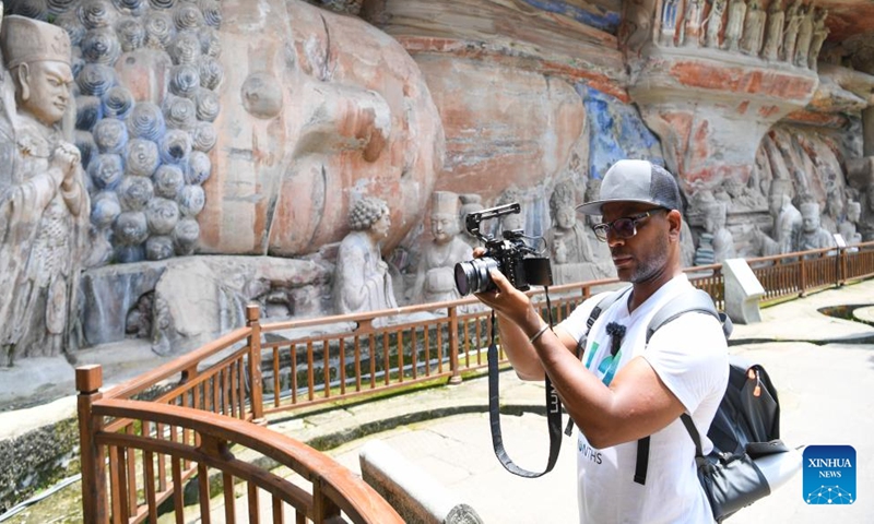 A tourist from abroad shoots a video at the scenic spot of Dazu Rock Carvings in southwest China's Chongqing, July 19, 2024.

Chongqing is soaring as a favored entry point for foreign tourists. This municipality has received more than 510,000 inbound foreign visitors in the first half of this year. (Xinhua/Wang Quanchao)