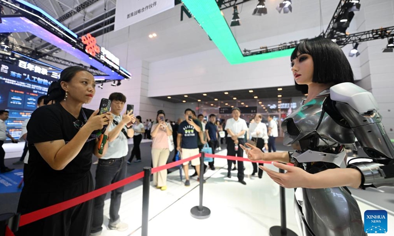 A visitor interacts with a humanoid robot at the World Intelligence Expo 2024 in north China's Tianjin, June 21, 2024. From coffee robots to humanoid robots, the four-day expo highlighted the diverse application scenarios of robots.