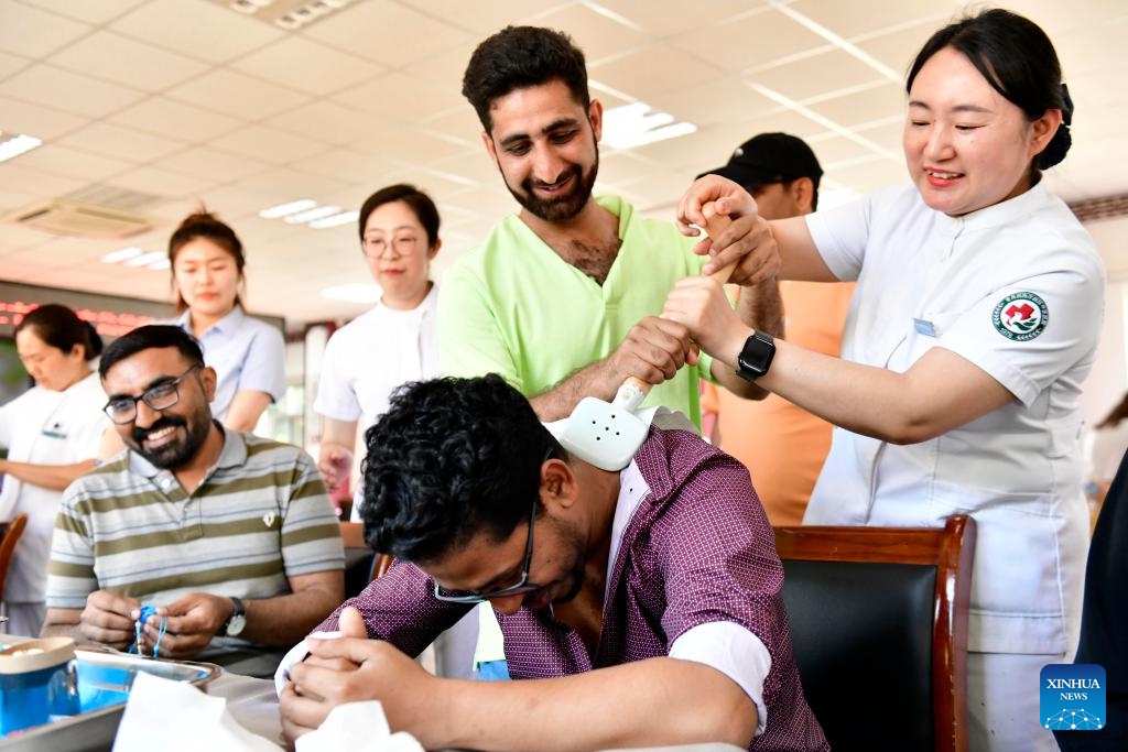 International students from Qingdao University experience the moxibustion therapy at a traditional Chinese medicine (TCM) hospital in Qingdao, east China's Shandong Province, June 18, 2024. Some international students from Qingdao University visited a local TCM hospital on Tuesday to experience the charm of TCM culture. Collaborated with several universities in the city, the hospital built a TCM experience base that has hosted more than 600 international students. (Photo: Xinhua)