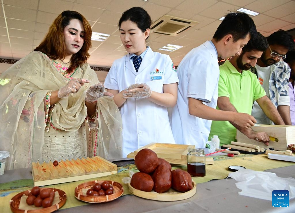 International students from Qingdao University learn to make hawthorn products at a traditional Chinese medicine (TCM) hospital in Qingdao, east China's Shandong Province, June 18, 2024. Some international students from Qingdao University visited a local TCM hospital on Tuesday to experience the charm of TCM culture. Collaborated with several universities in the city, the hospital built a TCM experience base that has hosted more than 600 international students. (Photo: Xinhua)