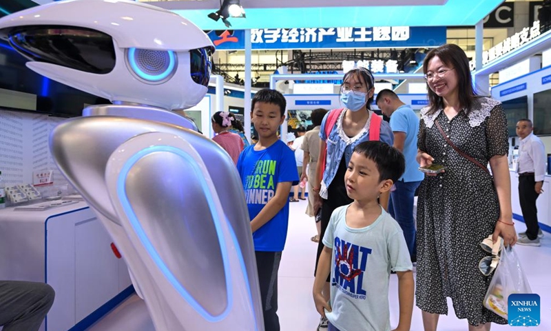 Visitors interact with a robot at the World Intelligence Expo 2024 in north China's Tianjin, June 22, 2024. From coffee robots to humanoid robots, the four-day expo highlighted the diverse application scenarios of robots.