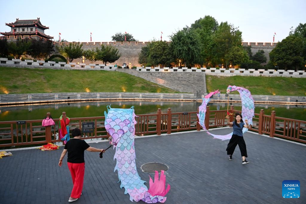 Photo taken on June 17, 2024 shows residents practicing dragon dance near ancient city wall in Xi'an, northwest China's Shaanxi Province. Xi'an, a city with over 3,100 years of history, served as the capital for 13 dynasties in Chinese history. It is also home to the world-renowned Terracotta warriors created in the Qin Dynasty (221-207 BC).(Photo: Xinhua)