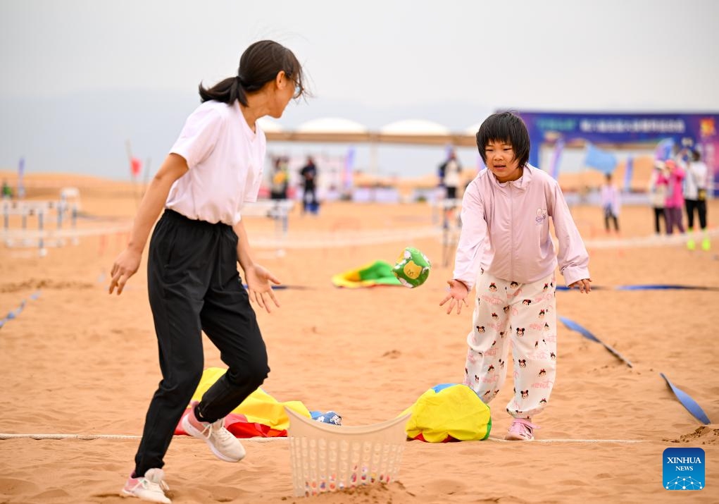 Contestants compete in a parent-child obstacle race event during the desert fun games at Shapotou scenic spot in Zhongwei, northwest China's Ningxia Hui Autonomous Region, July 7, 2024. The desert fun games is being held here from July 6 to 8, expected to attract more than 1,000 contestants. (Xinhua/Feng Kaihua)