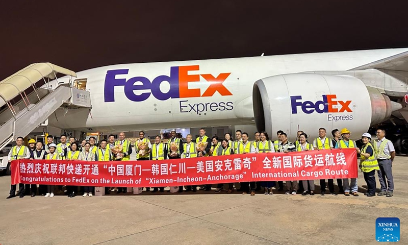 This undated photo shows staff members posing for a group photo to celebrate the launch of the cargo flight in Xiamen, southeast China's Fujian Province. The Federal Express Corporation (FedEx), a global express giant, has recently launched two new flights to the United States from the two coastal cities of Qingdao and Xiamen, China.(FedEx China/Handout via Xinhua)