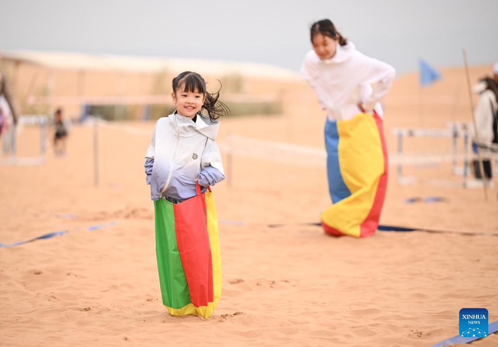 Contestants compete in a parent-child obstacle race event during the desert fun games at Shapotou scenic spot in Zhongwei, northwest China's Ningxia Hui Autonomous Region, July 7, 2024. The desert fun games is being held here from July 6 to 8, expected to attract more than 1,000 contestants. (Xinhua/Feng Kaihua)