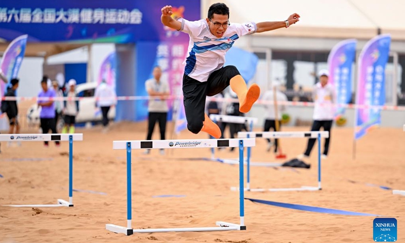 A contestant competes in a parent-child obstacle race event during the desert fun games at Shapotou scenic spot in Zhongwei, northwest China's Ningxia Hui Autonomous Region, July 7, 2024. The desert fun games is being held here from July 6 to 8, expected to attract more than 1,000 contestants. (Xinhua/Feng Kaihua)