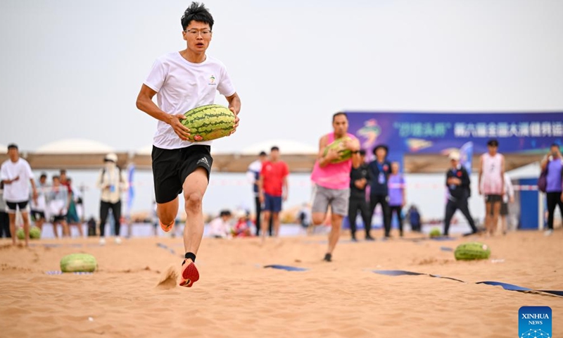 A contestant competes in a watermelon harvest event during the desert fun games at Shapotou scenic spot in Zhongwei, northwest China's Ningxia Hui Autonomous Region, July 7, 2024. The desert fun games is being held here from July 6 to 8, expected to attract more than 1,000 contestants. (Xinhua/Feng Kaihua)