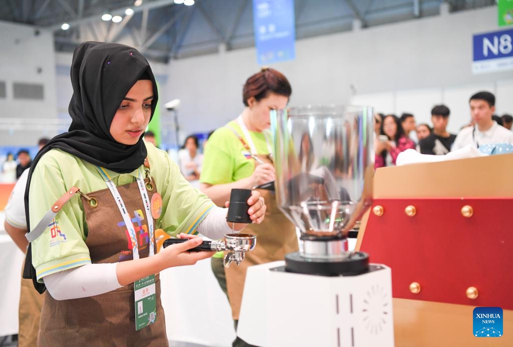 A contestant (front) is pictured during a contest of the second Belt and Road International Skills Competition in southwest China's Chongqing Municipality on June 24, 2024. The second Belt and Road International Skills Competition kicked off at Chongqing International Expo Center here on Monday, attracting participants from 61 countries and regions.(Photo: Xinhua)