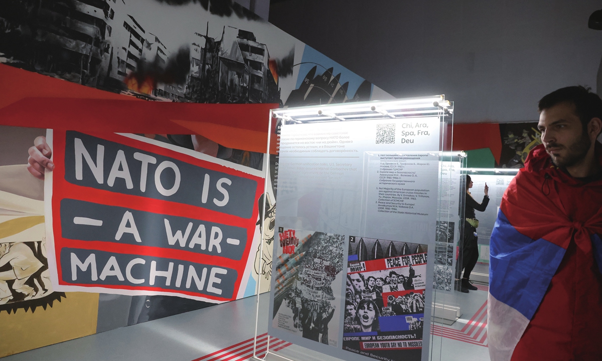A Serbian visitor looks at an anti-NATo poster at an exhibition in Sochi, Russia on March 6, 2024 Photo: VCG