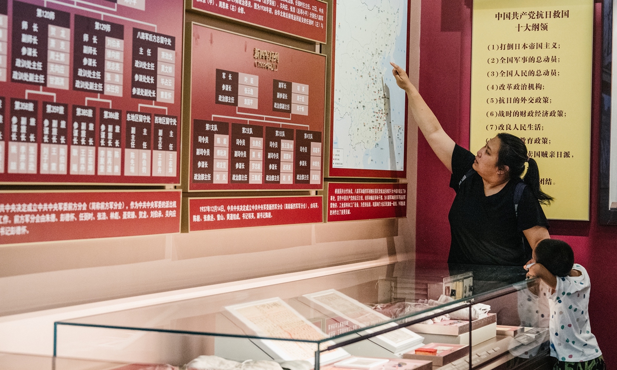 A mother teaches her son the history of the Party in front of a display board at the Museum of the CPC in Beijing on June 18, 2024. Photo: Li Hao/GT