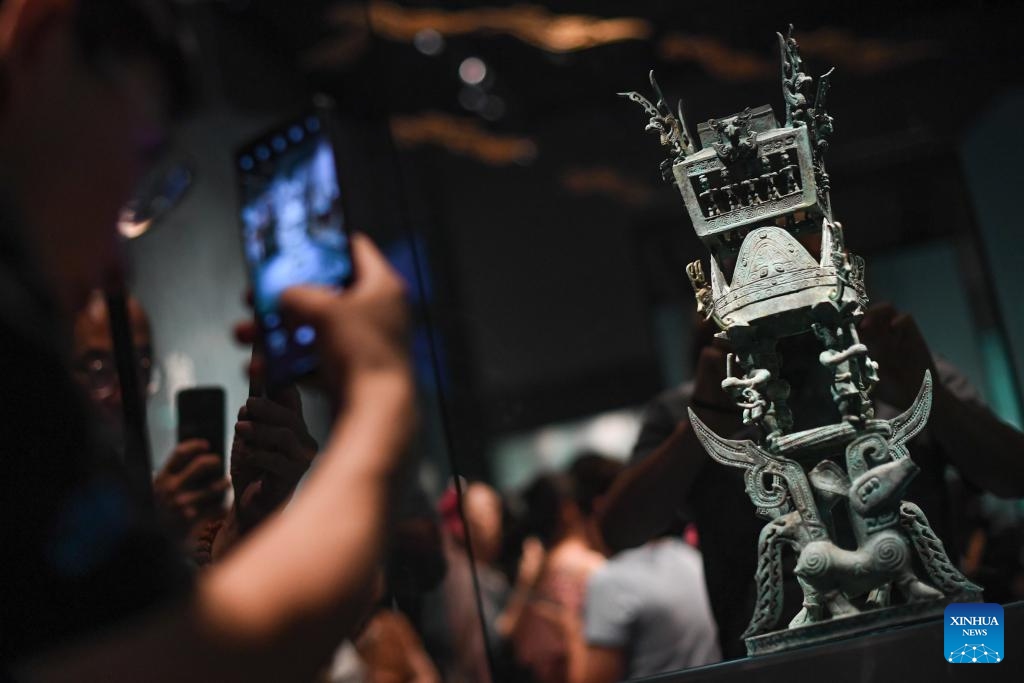 Visitors take photos of a bronze replica exhibit during an exhibition named Unveiling Sanxingdui and Jinsha of Ancient Shu Civilization at the Grand Canal Museum of Beijing, in Beijing, capital of China, June 27, 2024. With a total of 265 pieces of relics featuring ancient Shu civilization, the exhibition kicked off here on Thursday and will last until Oct. 10. (Photo: Xinhua)