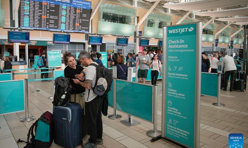 Passengers are seen at the WestJet check-in area at Vancouver International Airport in Richmond, British Columbia, Canada, June 29, 2024. Canada's second largest airline, the WestJet Group, said Friday it is outraged at an unexpected strike by its aircraft maintenance engineers.