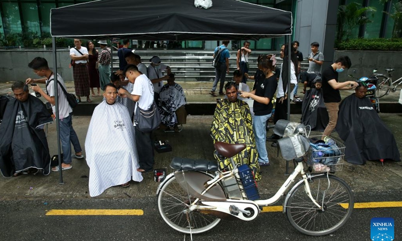 Young hairdressers from Myanmar Barber Academy offer free haircuts in Botataung Township of Yangon, Myanmar, June 29, 2024. (Xinhua/Myo Kyaw Soe)