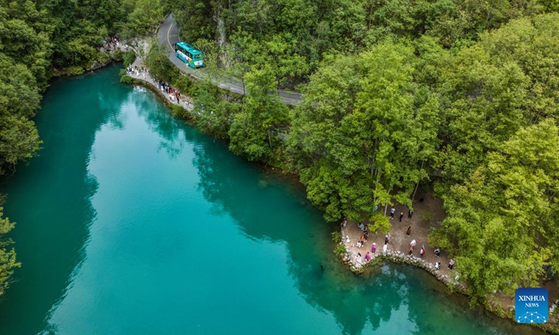 An aerial drone photo taken on May 16, 2024 shows a vehicle running in Xiaoqikong Township of Libo County, Bouyei-Miao Autonomous Prefecture of Qiannan, southwest China's Guizhou Province. In the past ten years, the rural road network in Guizhou Province has been significantly improved. By the end of 2023, the total mileage of rural roads in Guizhou has reached 185,000 kilometers. (Xinhua/Tao Liang)