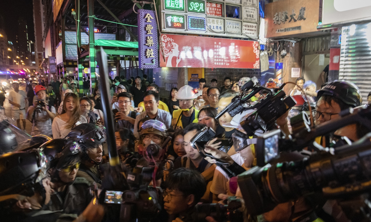 Police officers face a large crowd of what appears to be press as they move to arrest a rioter outside the Prince Edward police station in Hong Kong, on September 22, 2019. Photo: AFP