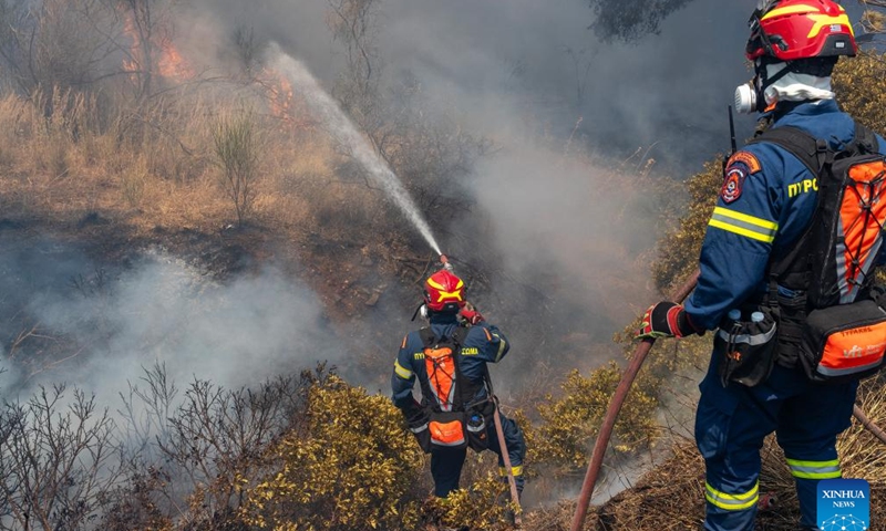 Firefighters try to put out a fire in the forest at Keratea, southeast of Athens, Greece, June 30, 2024.Since the start of the wildfire season on May 1, firefighters are called to handle dozens of wildfires every day across the country. (Xinhua/Marios Lolos)