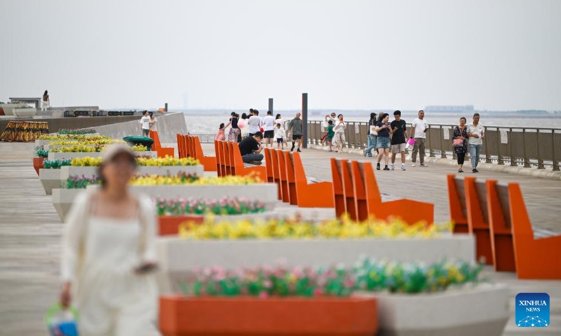 People visit a seaside park in the Binhai New Area of north China's Tianjin, June 29, 2024. Over the years, the city of Tianjin has worked on the ecological restoration and development of Bohai Sea.