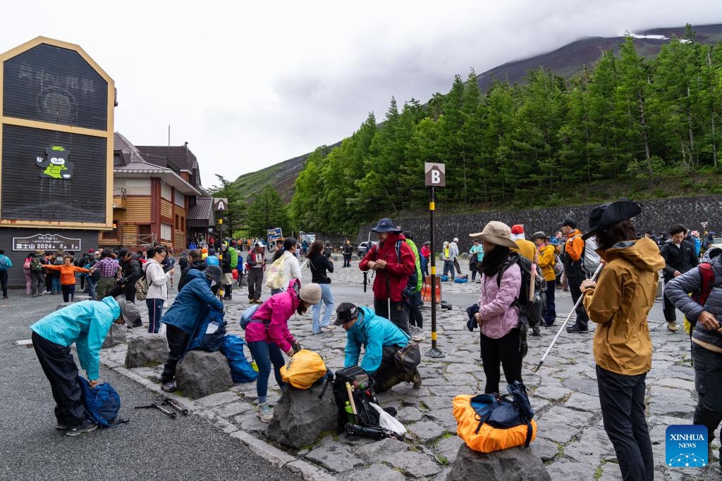 Hikers sort their bags at the Yoshida Trail of Mount Fuji in the prefecture of Yamanashi, Japan, July 1, 2024. The climbing season started Monday at Japan's renowned Mount Fuji with one of the four main hiking trails opened, after a mandatory hiking fee was introduced this year to address overtourism concerns.(Photo: Xinhua)