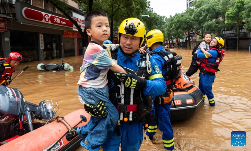 Rescuers transfer stranded residents in Pingjiang county, central China's Hunan Province, July 2, 2024. The flooding water in Pingjiang county is gradually declining. As of 6 p.m. on July 2, the water level of Pingjiang watch station of the Miluo River was 76.18 meters, still 5.68 meters above the warning mark, but 1.49 meters lower than the peak level. (Photo: Xinhua)