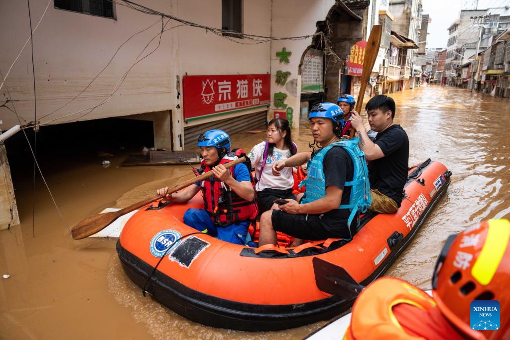 Rescuers transfer stranded residents in Pingjiang county, central China's Hunan Province, July 2, 2024. The flooding water in Pingjiang county is gradually declining. As of 6 p.m. on July 2, the water level of Pingjiang watch station of the Miluo River was 76.18 meters, still 5.68 meters above the warning mark, but 1.49 meters lower than the peak level. (Photo: Xinhua)