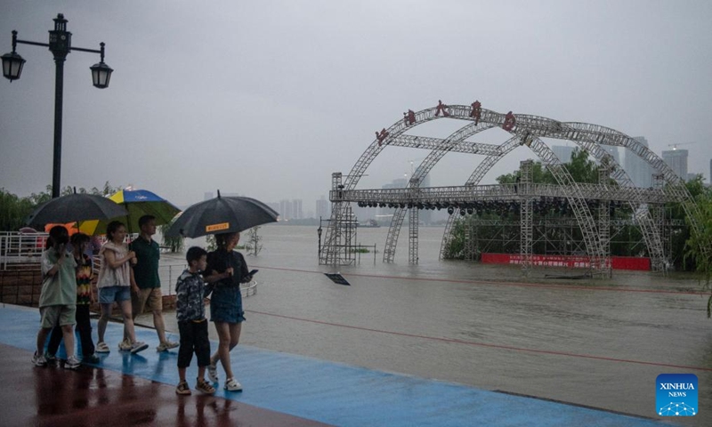 Pedestrians walk past the marshland by the Yangtze River in Hankou of Wuhan, central China's Hubei Province, July 1, 2024. Water levels in sections of the middle and lower reaches of the Yangtze River -- China's longest river -- below the estuary of Dongting Lake, have exceeded the warning mark, according to the Ministry of Water Resources Tuesday. (Photo: Xinhua)