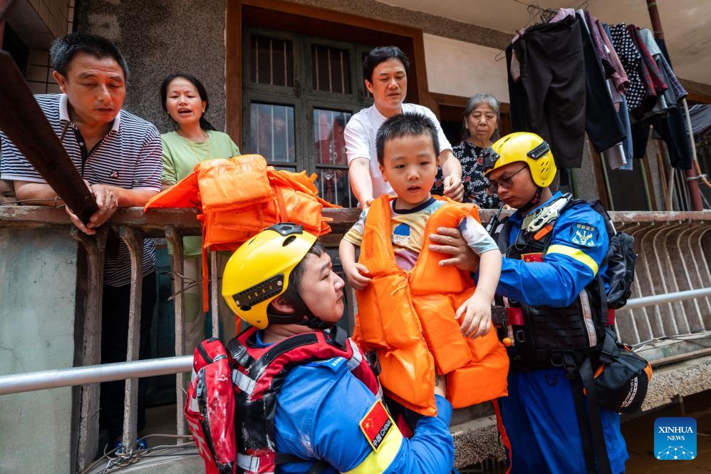 Rescuers transfer stranded residents in Pingjiang county, central China's Hunan Province, July 2, 2024. The flooding water in Pingjiang county is gradually declining. As of 6 p.m. on July 2, the water level of Pingjiang watch station of the Miluo River was 76.18 meters, still 5.68 meters above the warning mark, but 1.49 meters lower than the peak level. (Photo: Xinhua)