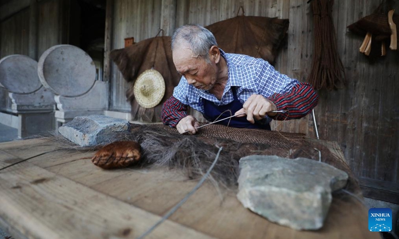 A craftsman makes a straw raincoat at Huangling Village of Wuyuan County, east China's Jiangxi Province, July 3, 2024. In recent years, Wuyuan County has been making efforts to promote rural tourism by exploring and utilizing its unique natural resources and traditional culture. Photo: Xinhua