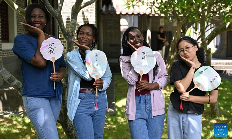 Foreigners pose for a group photo with traditional Chinese lacquer fans made by themselves in Haikou, south China's Hainan Province, July 6, 2024. Photo: Xinhua