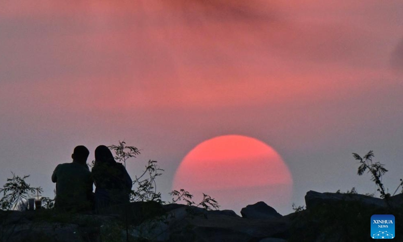 People view the sunset at a seaside in Jerudong, Brunei, July 26, 2024. (Photo by Jeffery Wong/Xinhua)