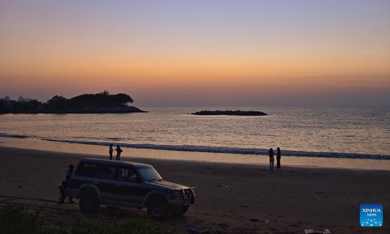 People view the sunset glow at a seaside in Jerudong, Brunei, July 26, 2024. (Photo by Jeffery Wong/Xinhua)