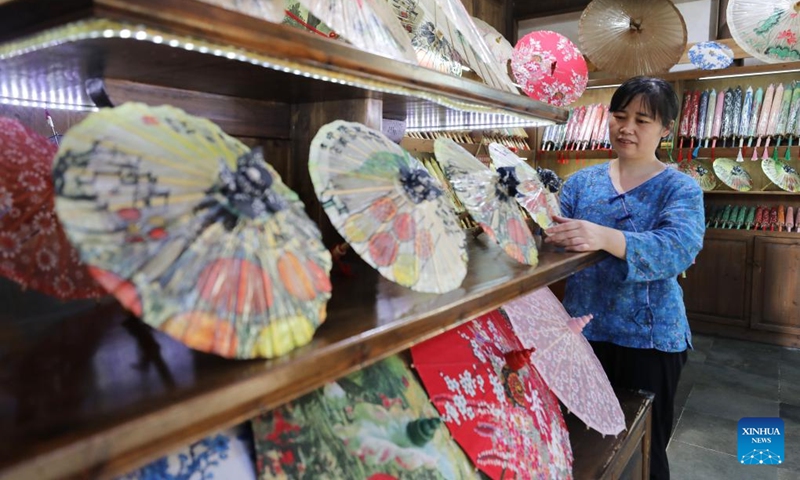 A staff member works at an oil-paper umbrella shop in Huangling Village of Wuyuan County, east China's Jiangxi Province, July 3, 2024. In recent years, Wuyuan County has been making efforts to promote rural tourism by exploring and utilizing its unique natural resources and traditional culture. Photo: Xinhua