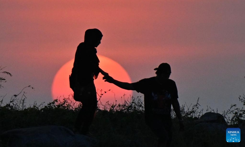 People view the sunset at a seaside in Jerudong, Brunei, July 26, 2024. (Photo by Jeffery Wong/Xinhua)