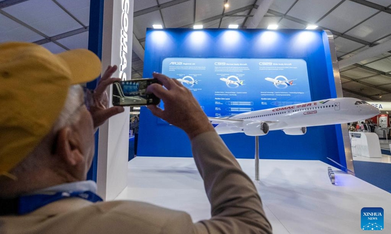 A visitor takes photos of a model of the C929 aircraft at the booth of aircraft developer Commercial Aircraft Corporation of China, Ltd. (COMAC) during the Farnborough International Airshow in Farnborough, Britain, July 22, 2024. The 2024 Farnborough International Airshow closed on July 26. Photo: Xinhua