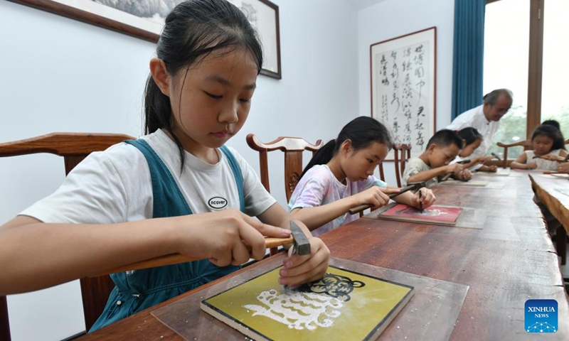 Pupils try the technique of porcelain carving at a museum in Hejian, north China's Hebei Province, July 26, 2024. Various training courses on intangible cultural heritages as shadow puppet, porcelain carving etc. targeting the school children are opened in the city during the summer vacation. Photo: Xinhua