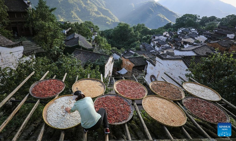 A woman dries farm produce at Huangling Village of Wuyuan County, east China's Jiangxi Province, July 3, 2024. In recent years, Wuyuan County has been making efforts to promote rural tourism by exploring and utilizing its unique natural resources and traditional culture. Photo: Xinhua