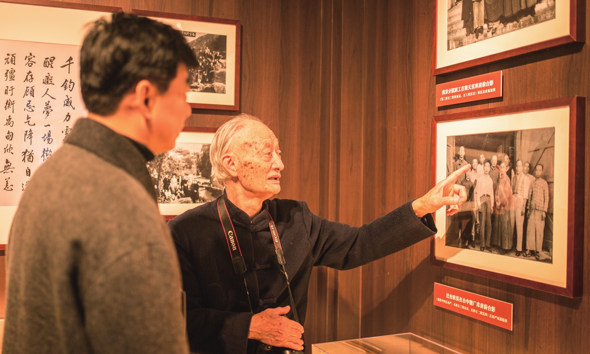 Zhuang Ling (right) points at an old photo at the southward evacuation of the Palace Museum's artifacts exhibition in Shanghai in December 2023. Photo: Shan Jie/GT